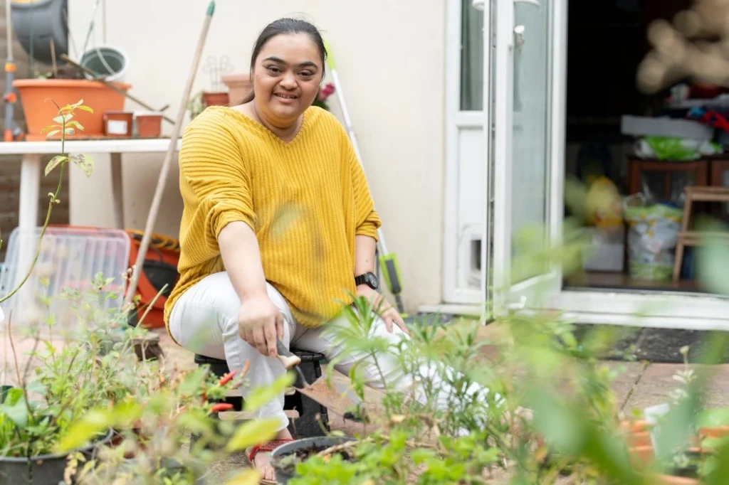 Happy Indian woman with down syndrome outside gardening