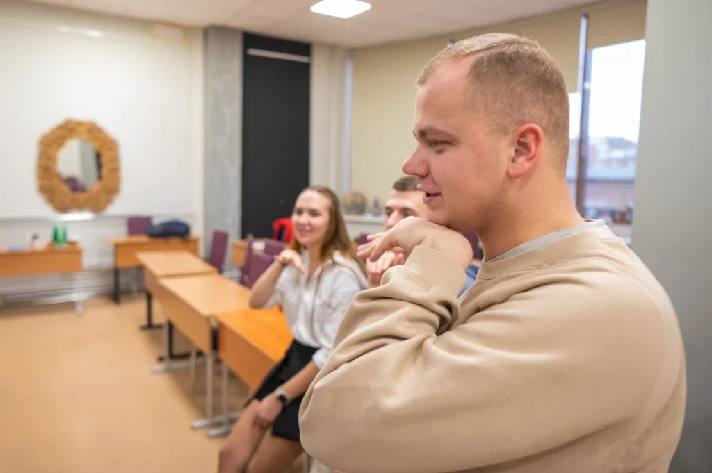 Deaf man using sign language with friends in class